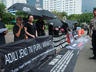 Spanduk berisi tuntutan kepada Wiranto dibentangkan saat aksi Kamisan ke-482 di depan Istana Merdeka, Jakarta, Kamis (23/2). Mereka menuntut Presiden Jokowi mengumumkan hasil temuan TPF ke publik. (Liputan6.com/Gempur M Surya) 