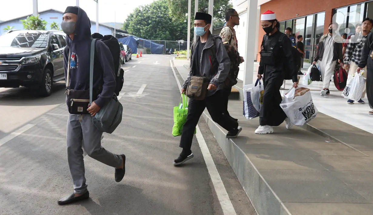 Warga Negara Indonesia (WNI) yang telah tiba di tanah air menuju bus yang membawa mereka menginap sementara di Asrama Haji Pondok Gede Jakarta. (Liputan6.com/Helmi Fithriansyah)