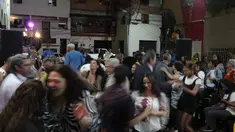 Orang-orang menari selama peresmian festival film pertama yang menampilkan film-film Venezuela di lingkungan San Agustín di Caracas, Venezuela (23/5/2022). Warga di San Agustin telah mengadakan acara budaya seperti ini selama bertahun-tahun, untuk mengubah budaya mereka yang dulu. (AP Photo/Ariana Cubillos)