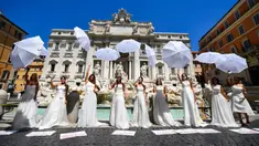 Pengantin perempuan yang mengenakan gaun pernikahan mereka melakukan flashmob saat aksi protes di Trevi Fountain, Roma, Selasa (7/7/2020). Mereka memprotes kebijakan pemerintah Italia yang masih melarang adanya acara pernikahan, meski penerapan lockdown sudah dilonggarkan. (Tiziana FABI/AFP)
