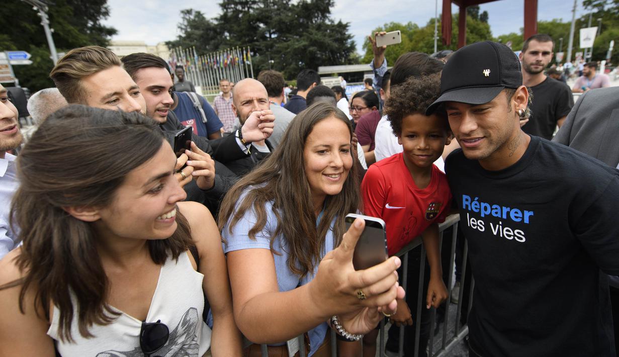Bintang Paris Saint-Germain, Neymar Jr, foto bersama penggemarnya usai menghadiri konferensi pers di Kantor PBB, Jenewa, (15/8/2017). Neymar Jr akan fokus membantu orang-orang cacat dan terpuruk dalam kemiskinan. (AP/Laurent Gillieron)