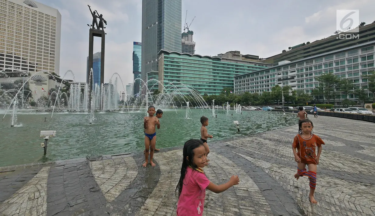 Sejumlah anak bermain air di kolam Bundaran HI, Jakarta, Senin (17/6/2019). Meski ada larangan berenang, sejumlah anak tetap nekat menyebur ke kolam Bundaran HI. (Liputan6.com/Herman Zakharia)