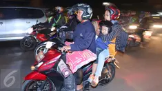 Pemudik motor dengan membawa anak kecil melintasi jalur Pantura, Jawa Barat, Jumat (1/7). Masih banyak pemudik dengan sepeda motor yang nekat membawa anak kecil dan melebihi kapasitas muatan. (Liputan6.com/Angga Yuniar)