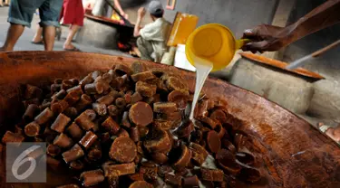 Pekerja menuangkan santan di atas gula aren di kawasan Pasar Minggu, Jakarta, Kamis (23/6). Produksi dodol Betawi mengalami peningkatan tajam seiring permintaan jelang Lebaran. (Liputan6.com/Gempur M Surya)