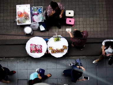 Pedagang buah-buahan melayani pelanggan di Bangkok, Thailand (20/9). Bangkok dikenal punya sejarah panjang sebagai pusat makanan jalanan di dunia. (AFP Photo/Jewel Samad)