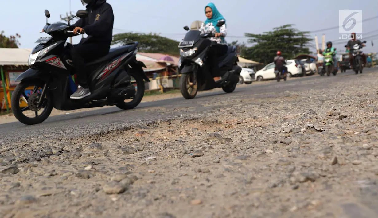 Pengendara menghindari jalan berlubang di kawasan Gas Alam, Depok, Jawa Barat, Kamis (4/10). Jalan rusak di kawasan tersebut sudah berlangsung selama bertahun-tahun. (Liputan6.com/Immanuel Antonius)