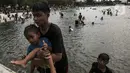 Pengunjung berenang di Pantai Karnaval Ancol, Jakarta, Jumat (14/5/2021). Ancol dibuka khusus bagi warga ber-KTP DKI Jakarta dan membatasi jumlah wisatawan dengan kapasitas 30 persen. (Liputan6.com/Johan Tallo)