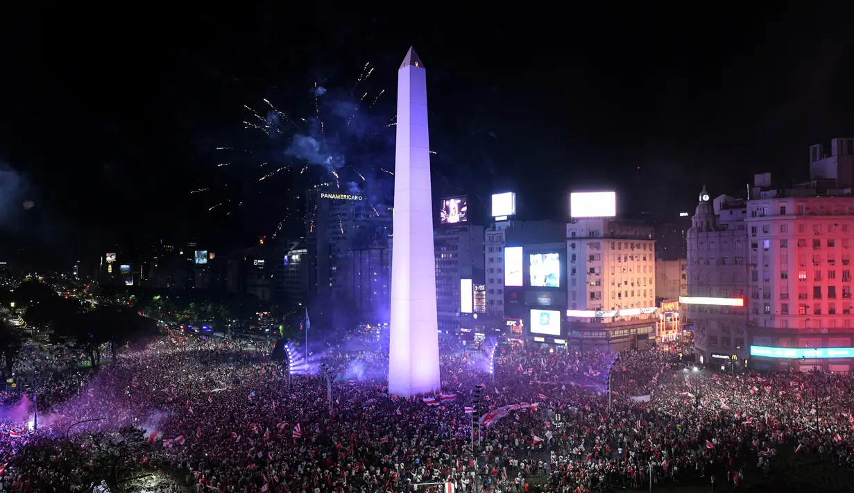 Suporter River Plate merayakan gelar juara Copa Libertadores di Obelisk, Buenos Aires, Argentina, Minggu (9/12). River Plate merebut gelar juara Copa Libertadores usai menaklukkan Boca Juniors dengan skor 3-1. (AP Photo/Gustavo Garello)