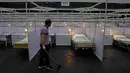 Seorang pekerja membersihkan rumah sakit lapangan sementara yang didirikan di Asia World Expo di Hong Kong, Sabtu (1/8/2020). Pusat pameran di dekat Bandara Internasional Hong Kong itu diubah menjadi fasilitas untuk menampung pasien COVID-19 dengan gejala ringan.  (AP Photo/Kin Cheung)