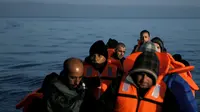 Pengungsi dan imigran saat berada di kapal di sampan kecil usai melintasi pulau Lesbos, Yunani, Senin (9/11). Sejak tahun 2015 lebih dari 590.000 imigran menyeberang ke Yunani akibat perang yang terjadi di Suriah. (REUTERS/Alkis Konstantinidis)