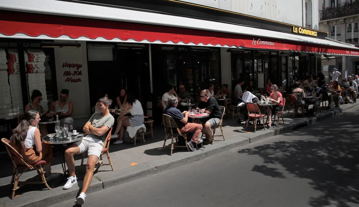 Orang-orang duduk di teras kafe di Paris, Selasa (2/6/2020). Warga Paris terkurung selama berbulan-bulan karena lockdown Corona namun, kini sebagian kafe dan restoran di kota itu dibuka kembali usai pelonggaran pembatasan. (AP Photo/Christophe Ena)