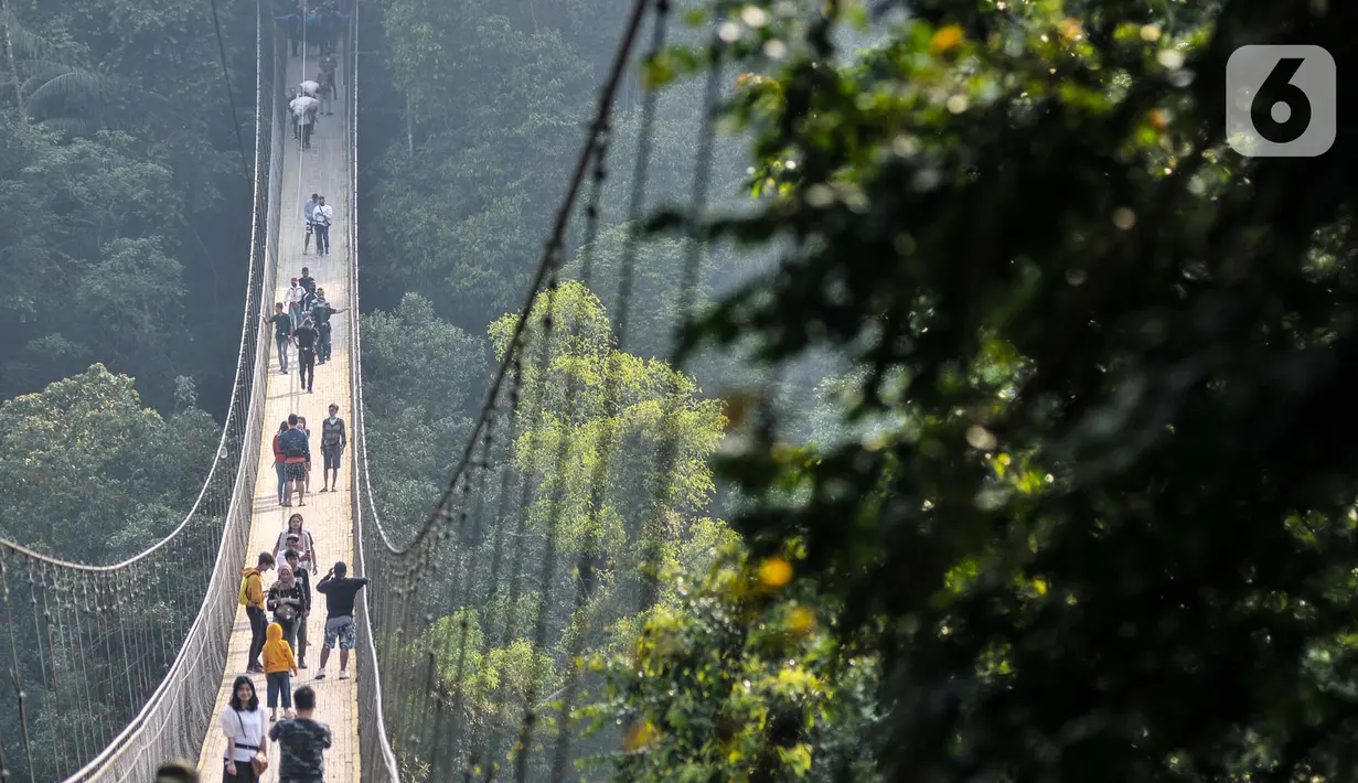 Pengunjung melintasi Jembatan Gantung Situ Gunung di Sukabumi, Minggu (20/9/2020). Seperti diketahui, Jembatan Gantung tersebut resmi dibuka untuk umum pada 2018 lalu itu memiliki panjang 243 meter dengan lebar 1,2 meter dan berada di atas ketinggian 107 meter. (merdeka.com/Iqbal S. Nugroho)