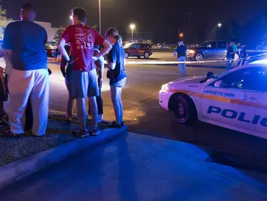 Sejumlah warga menunggu kabar di luar gedung bioskop Lafayette, Louisiana, AS, Kamis (23/7/ 2015). Pria bersenjata  melepaskan tembakan pada Kamis malam  yang  menewaskan dua orang dan melukai tujuh orang lainnya.(REUTERS/Lee Celano)