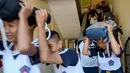 Sejumlah pelajar membawa tas mereka menuruni tangga saat mengikuti simulasi gempa dan tsunami di Jimbaran, Bali (5/11/2019). Seperti diketahui, gempa bumi bawah laut berkekuatan 9,1 SR pada tahun 2004 lalu telah memicu tsunami yang menewaskan lebih dari 170.000 orang. (AFP Photo/Sonny Tumbelaka)
