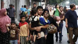 Puluhan keluarga beserta anak-anak harus keluar dari Shujayeh, (20/7/2014), menyusul meningkatnya serangan militer Israel ke Gaza, Palestina. (REUTERS/Finbarr O'Reilly)