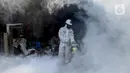 Petugas melakukan fogging nyamuk demam berdarah dengue (DBD) di kampung pemulung Pancoran, Jakarta, Rabu (22/2/2020). Pemerintah mengimbau warga mengantisipasi penyebaran DBD saat musim pancaroba pada April hingga Mei lantaran saat ini terjadi pandemi virus corona COVID-19. (merdeka.com/Imam Buhori)