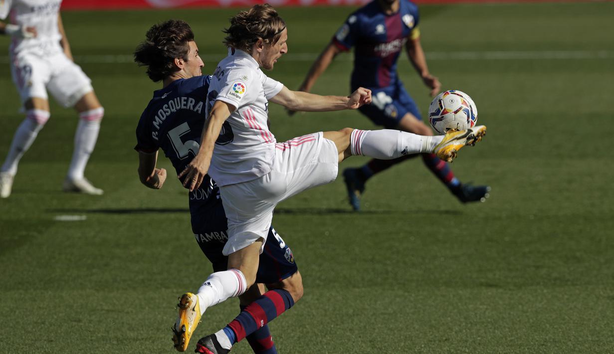 Gelandang Real Madrid, Luka Modric, berebut bola dengan gelandang Huesca, Pedro Mosquera, pada laga lanjutan Liga Spanyol di Stadion Alfredo Di Stefano, Sabtu (31/10/2020) malam WIB. Real Madrid menang 4-1 atas Huesca. (AP Photo/Manu Fernandez)