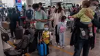 Orang-orang mengantre check-in untuk penerbangan domestik menjelang liburan "Golden Week" di Bandara Internasional Ibu Kota Beijing pada 30 September 2020. Gelombang liburan melanda China yang warganya merayakan libur panjang, yang dikenal dengan Golden Week. (NICOLAS ASFOURI / AFP)