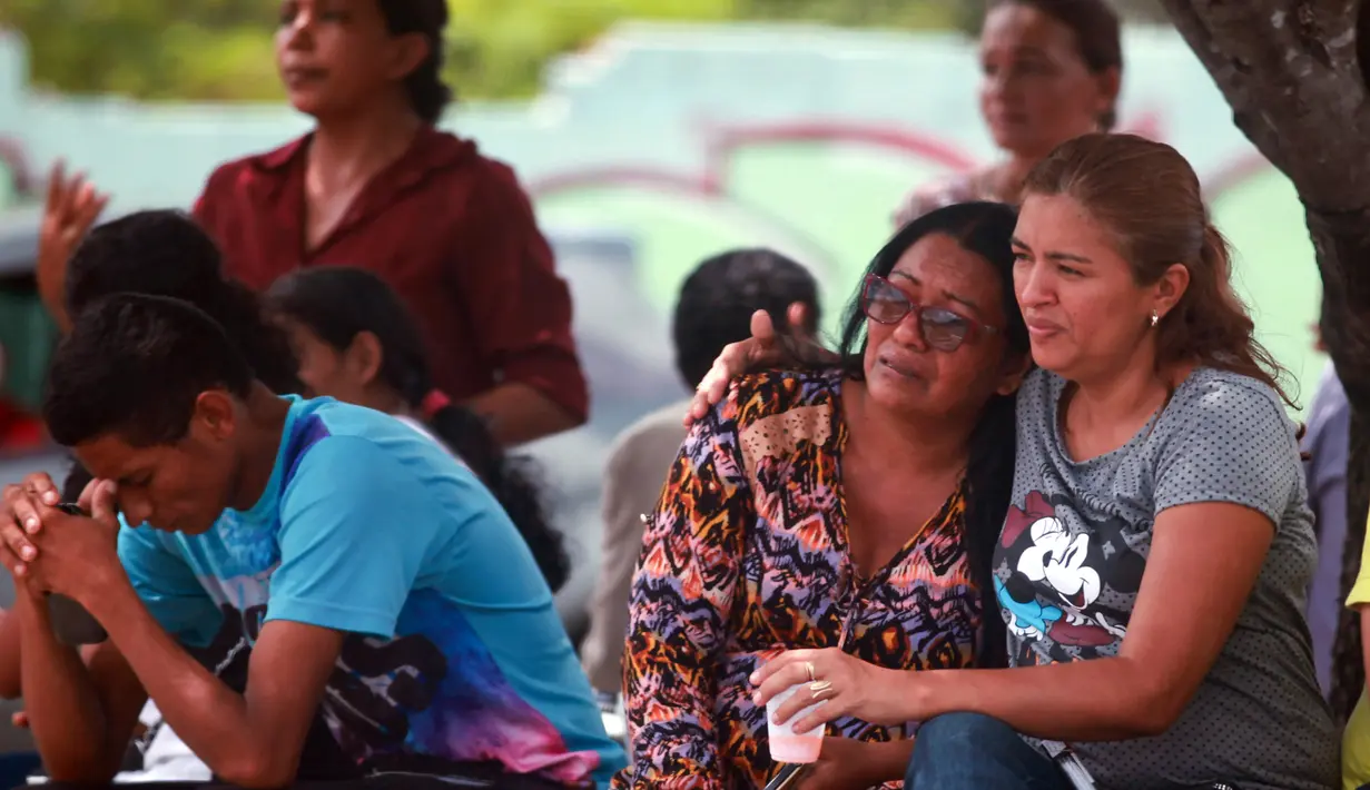 Kerabat narapidana menunggu kabar di depan Medical Local Institute (IML) setelah kerusuhan di dalam penjara kota Amazon, Brasil, Senin (2/1). 60 narapidana tewas dalam kerusuhan yang melibatkan dua kelompok di penjara tersebut. (REUTERS/Michael Dantas)