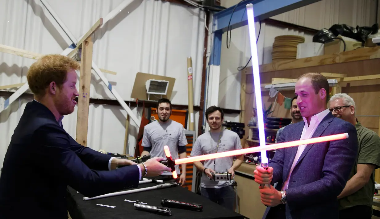 Pangeran William dan Harry bermain pedang sinar saat berkunjung ke studio pembuatan film Star Wars di Pinewood Studios, London, Selasa (19/4). Dua Pangeran Inggris itu berkeliling Pinewood untuk mengunjungi workshop produksi film Star Wars (REUTERS/Pool)