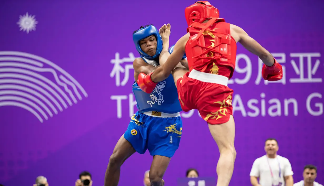 Atlet wushu Indonesia, Samuel Marbun (kiri) berusaha mengadang tendangan atlet wushu Iran, Afsin Shalimi pada laga final cabor wushu nomor sanda kelas 65kg putra Asian Games 2022 di Xiaoshan Guali Sports Centre, Hangzhou, China, Kamis (28/9/2023). (NOC Indonesia/Naif Al'as)
