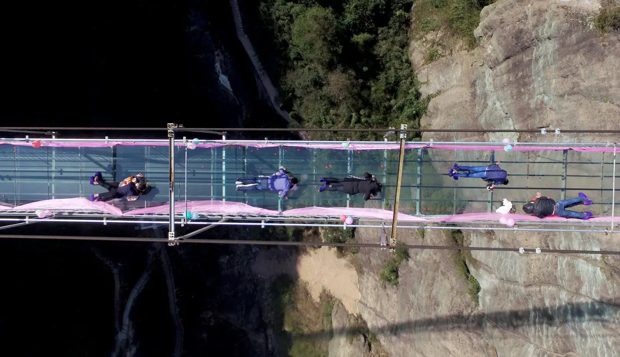 Sejumlah pasangan berciuman diatas sebuah jembatan kaca saat mengikuti kontes berciuman di Hari Valentine di Pingjiang, Provinsi Hunan, China (14/2). Kontes ini digelar untuk merayakan hari valentine yang jatuh pada setiap tanggal 14 Februari. (STR / AFP)