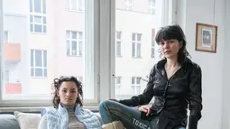 Elena Buscaino (kiri) dan Mina Bonakdar berpose dengan Riot Pants mereka di Berlin pada 5 Februari 2021. Aktivis feminis itu sedang dalam misi menghentikan manspreading -- kebiasaan buruk penumpang pria yang duduk dengan kaki melebar sehingga memakan dua kursi kereta sekaligus. (STEFANIE LOOS/AFP)