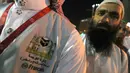 Seorang penerjemah menunggu untuk membantu jemaah haji di kota suci Makkah, Arab Saudi, 17 Agustus 2018. Para penerjemah ini bisa dicirikan dengan pria yang memakai rompi abu-abu, dan di dadanya dibordir nama bahasa yang dikuasai. (AFP/AHMAD AL-RUBAYE)