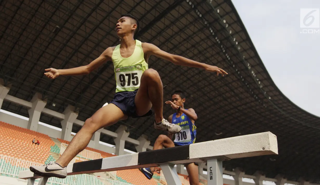 Pelari Sumatra Utara, Loudry Rafael, melakukan lompatan saat Kejurnas Atletik nomor lari 2.000 meter steeplechase putra di Stadion Pakansari, Bogor, Selasa (6/8/2019). Kejurnas tahun ini juga dilakukan untuk kualifikasi menjelang PON. (Bola.com/Vitalis Yogi Trisna)