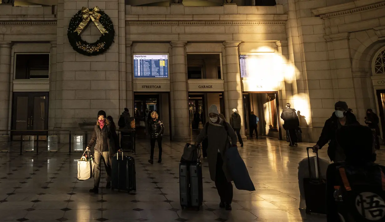 Orang-orang tiba di stasiun kereta Union Station di Washington, DC, Kamis (23/12/2021). Jutaan orang Amerika bepergian pada 23 Desember 2021, selama salah satu hari perjalanan tersibuk di musim liburan, ketika infeksi Covid dengan Omicron melampaui puncak gelombang varian Delta. (Pedro Ugarte/AFP)