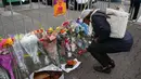 Seorang wanita menaruh lilin di tempat peringatan Gudang Terbakar di California, AS, Senin (5/12). Warga bersimpati atas peristiwa kebakaran gudang dengan memberikan bunga dan benda-benda lainnya. (REUTERS / Lucy Nicholson)