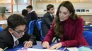 Kate Middleton, Duchess of Cambridge, berinteraksi dengan siswa selama kunjungan ke Nower Hill High School di Harrow, London utara (24/11/2021). Ia mengikuti pelajaran sains yang mempelajari ilmu saraf dan pentingnya perkembangan anak usia dini bersama para siswa. (AFP/Pool/Kirsty Wigglesworth)