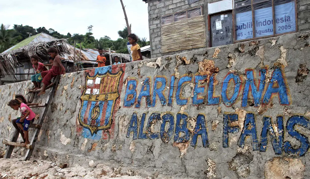 Anak-anak Alor bermain dekat tembok mural Barcelona fans, Klub Spanyol ini sangat terkenal di daerah ini. (Bola.com/Nicklas Hanoatubun)