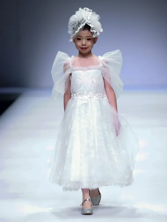Seorang model anak menampilkan koleksi busana dari KUNJIE karya Liu Shuming pada gelaran China Fashion Week di Beijing, China, Selasa (27/10/2020). (STR / AFP)