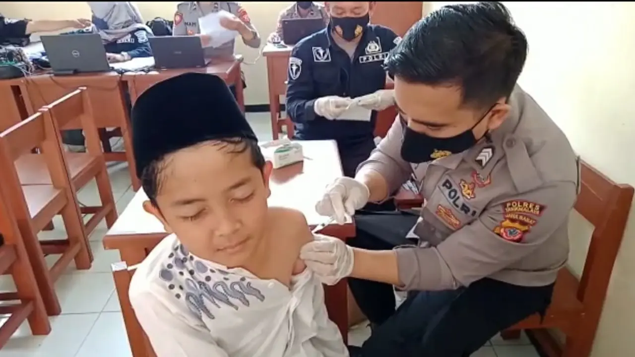 Salah seorang pelajar di Tasikmalaya tengah mendapatkan vaksinasi dari seorang petugas Polres Tasikmalaya.
