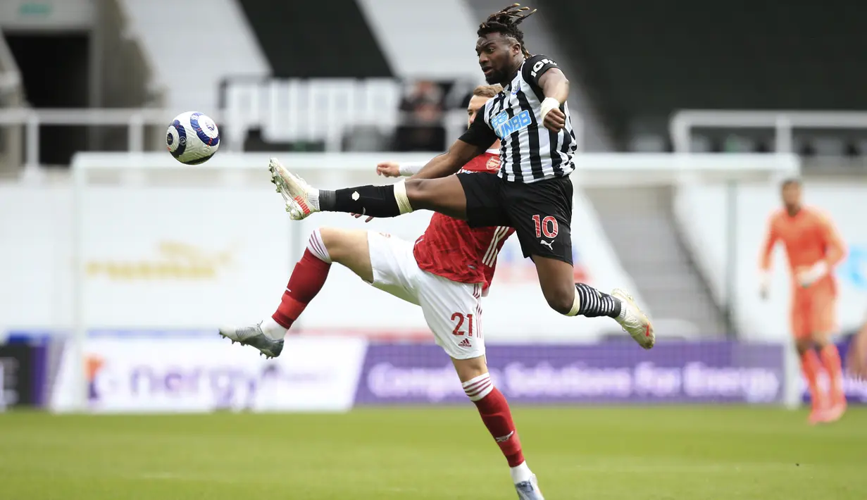 Gelandang Newcastle United, Allan Saint-Maximin berebut bola dengan bek Arsenal, Calum Chambers pada pertandingan lanjutan Liga Inggris di stadion St James 'Park, di Newcastle, Inggris, Minggu (2/5/2021). Sementara Newcastle United kian terpuruk di peringkat ke-17. (Lindsey Parnaby/Pool via AP)