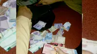 Barang bukti uang hasil curian dari dua tersangka yang ditangkap di Makassar, Sulawesi Selatan. (Liputan6.com/Eka Hakim)