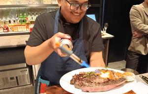 Chef Adam Rizal dari SKYE beratraksi sebelum menghidangkan steak OP Ribs. (dok. Liputan6.com/Dinny Mutiah)