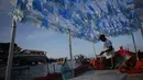 Seorang nelayan mempersiapkan kapalnya untuk membawa persembahan ke laut saat perayaan Dewi Laut Yemanja di Salvador, Brasil (2/2). Dalam ritual ini mereka meminta perlindungan kepada Dewi Laut. (AP Photo / Eraldo Peres)