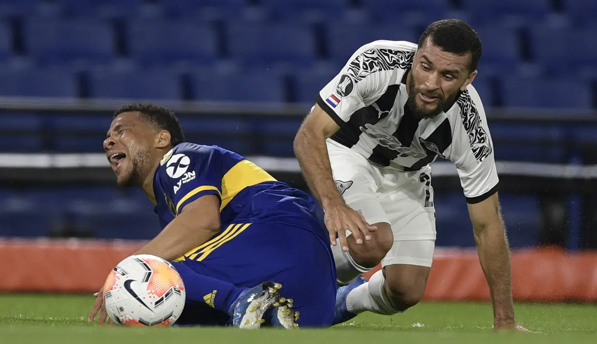 Bek Boca Juniors, Frank Fabra, berebut bola dengan penyerang Libertad, Antonio Bareiro, pada laga grup H Copa Libertadores di Estadio La Bombonera, Rabu (30/9/2020) dini hari WIB. Boca Juniors bermain imbang 0-0 atas Libertad. (Juan Mabromata/Pool via AP)