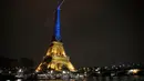 Menara Eiffel diterangi dengan warna bendera Ukraina untuk menandai peringatan satu tahun invasi Rusia ke negara itu di Paris, Prancis, 23 Januari 2023. (AP Photo/Christophe Ena)