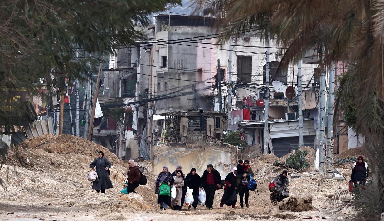 Warga Palestina meninggalkan rumah mereka untuk menyelamatkan diri selama serangan tentara Israel di kamp pengungsi Nur Shams dekat Tulkarem di Tepi Barat yang diduduki pada 11 Februari 2025. (Zain JAAFAR/AFP)