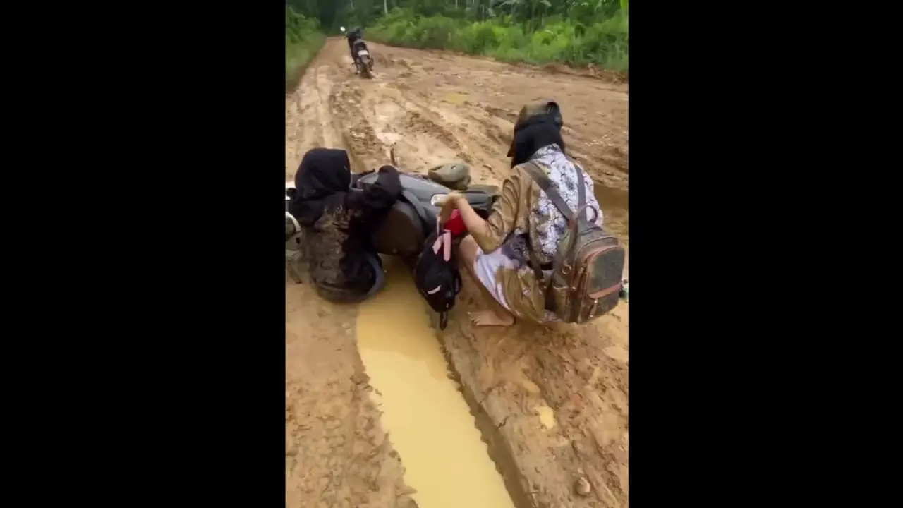 Pelajar jatuh saat melintasi jalan rusak di Kaltim. (Istimewa)