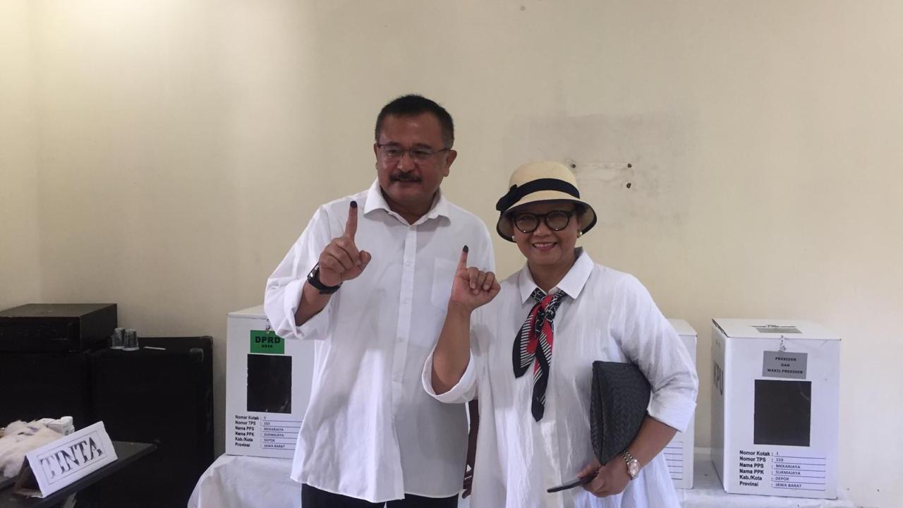 Menlu Retno Marsudi dan suami menujukkan jarinya yang sudah diberi tinta usai memberikan hak suaranya di TPS Pesona Khayangan, Kota Depok, Jawa Barat (Liputan6.com/Teddy Tri Setio Berty)