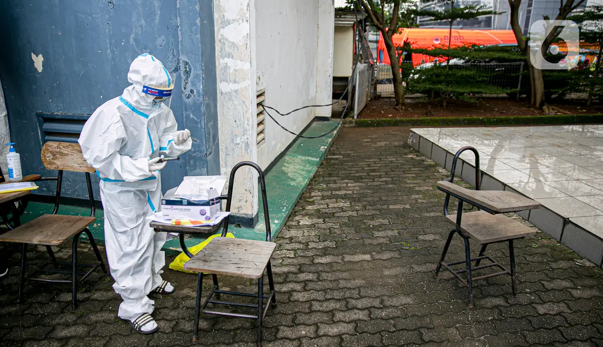 Petugas medis bersiap melakukan swab antigen terhadap pengungsi banjir di Universitas Borobudur, Cipinang Melayu, Jakarta, Minggu (21/2/2021). Swab antigen COVID-19 terhadap pengungsi dilakukan mengingat di pengungsian mereka tidur berhimpitan. (Liputan6.com/Faizal Fanani)