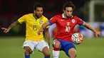 Gelandang Chile, Jorge Valdivia (kanan) berusaha mengontrol bola dari kejaran bek Brasil, Dani Alves pada kualifikasi Piala Dunia 2018 di Santiago, Chile (8/10/2015). Chile menang atas Brasil dengan skor 2-0. (AFP PHOTO/MARTIN BERNETTI)
