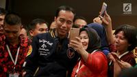 Capres nomor 01 Joko Widodo berswafoto dengan pendukung usai bersilaturahmi dengan pengurus Tim Kampanye Daerah di Gorontalo, Kamis (28/2). Jokowi meminta pendukungnya untuk bekerja makin keras guna memenangkan Pemilu 2019. (Liputan6.com/Arfandi Ibrahim)