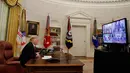 Presiden AS Donald Trump berbicara dengan prajurit militer melalui konferensi video di Gedung Putih, Selasa (25/12). Prajurit tersebut ditempatkan di Guam, Qatar, Alaska, dan dua kelompok di Bahrain. (AP Photo/Jacquelyn Martin)