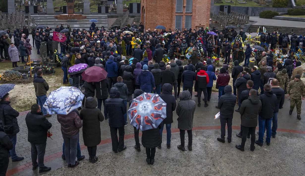 Keluarga dan teman menghadiri pemakaman Sersan Kostiv Andrew (37) yang tewas dalam perang dengan Rusia di pemakaman Lychakiv, Lviv, Ukraina, Selasa (5/4/2022). (AP Photo/Nariman El-Mofty)