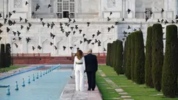 Presiden AS Donald Trump dan Ibu Negara Melania Trump berjalan saat mengunjungi Taj Mahal di Agra, India, Senin (24/2/2020). Kunjungan Donald Trump bertujuan memperdalam hubungan antara Amerika Serikat dan India. (Mandel NGAN/AFP)
